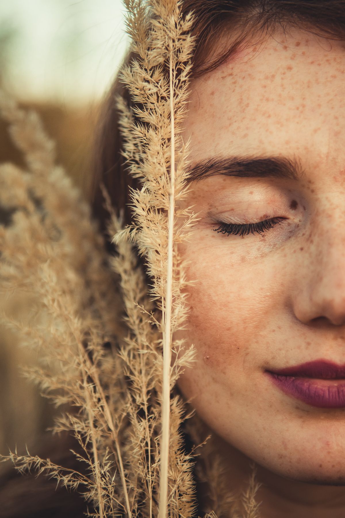 A woman's face touching a plant. With therapy for women in NYC, NY, you can learn how to manage anxiety & stress. Get started with a therapist for women today!