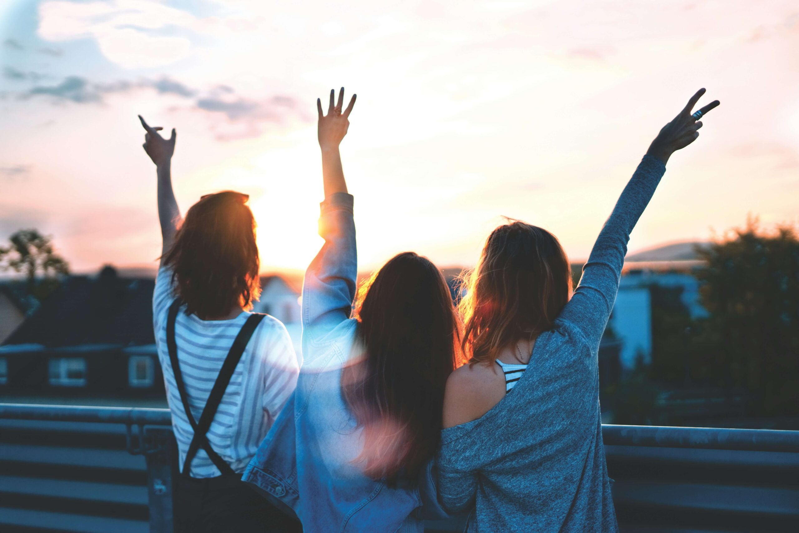 Three friends standing by a sunset. A women's issues therapist in NYC, NY can help you develop strategies for stress management. Begin working with a therapist for women today!